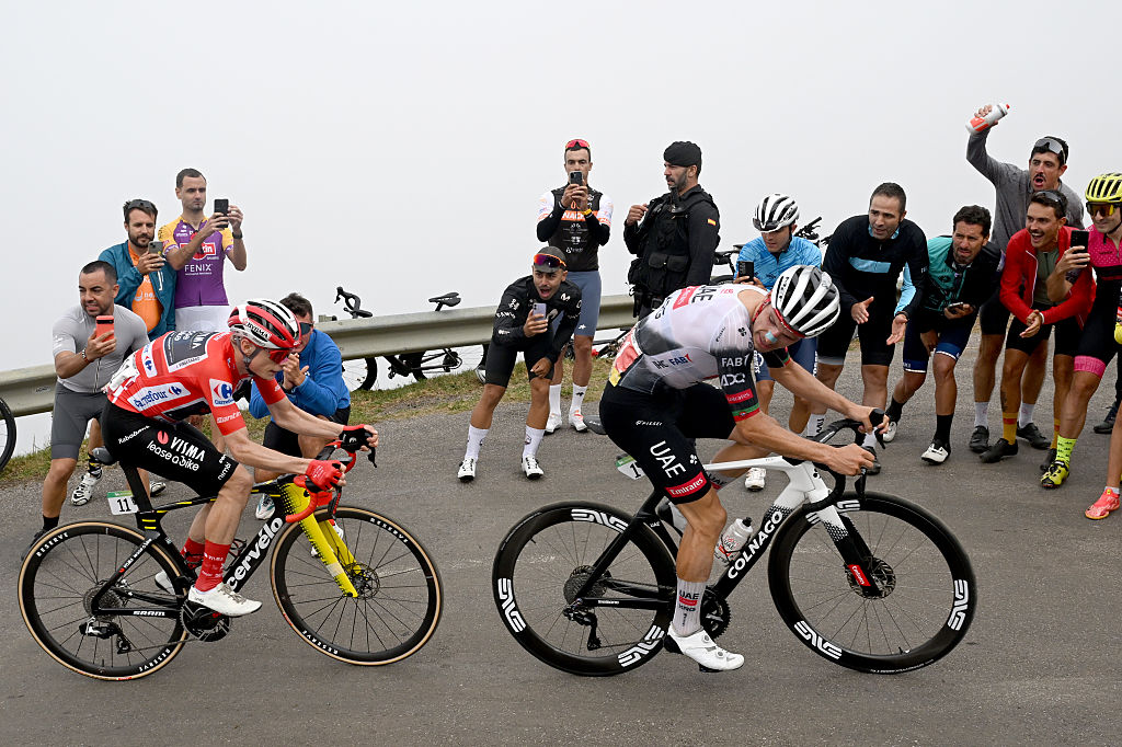 L'ANGLIRU, SPAIN - SEPTEMBER 05: (L-R) Jonas Vingegaard of Denmark and Team Visma | Lease a Bike - Red Leader Jersey and stage winner Joao Almeida of Portugal and UAE Team Emirates - XRG compete climbing to the L'Angliru while fans cheer during the La Vuelta - 80th Tour of Spain 2025, Stage 13 a 203.7km stage from Cabezon de la Sal to L'Angliru 1556m / #UCIWT / on September 05, 2025 in L'Angliru, Spain. (Photo by Dario Belingheri/Getty Images)
