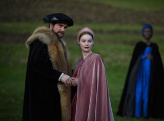 Henry (Mark Stanley) and Jane (Lola Petticrew) stand outside, their hands clasped together, as Anne (Jodie Turner-Smith) watches from the background