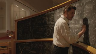 Reed Richards writing on a long chalk board in The Fantastic Four: First Steps