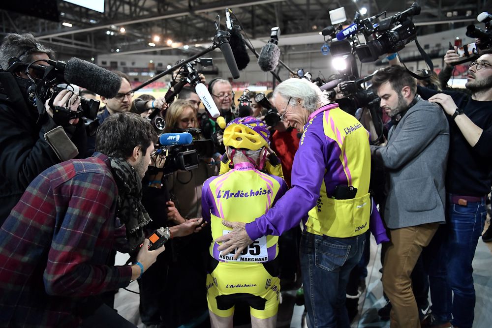 Media gather around Robert Marchand after his record ride.