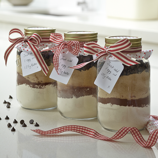 layered baking mixing in glass jar with ribbon and white background