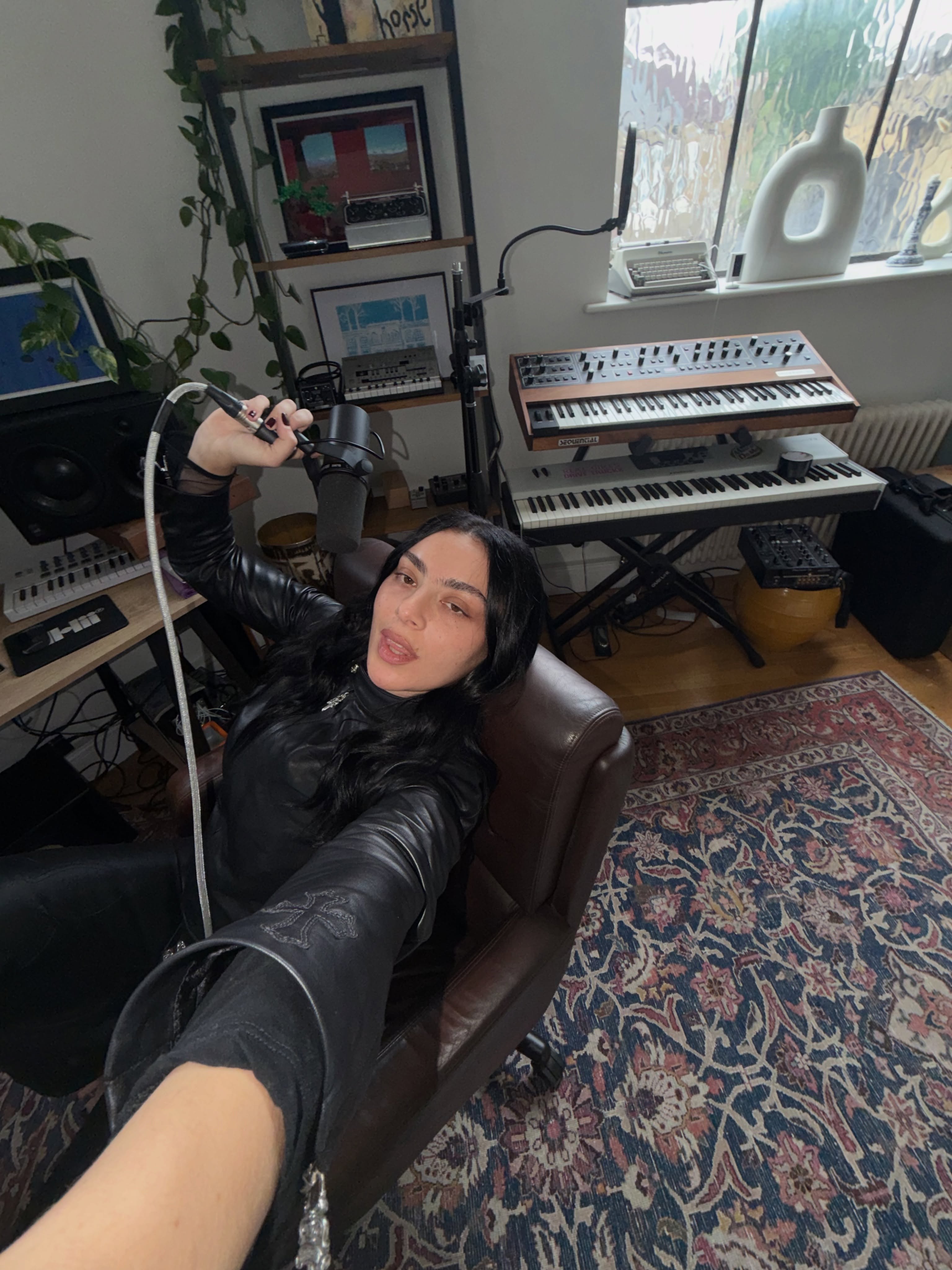An image of Charli XCX in the studio wearing black nail polish.