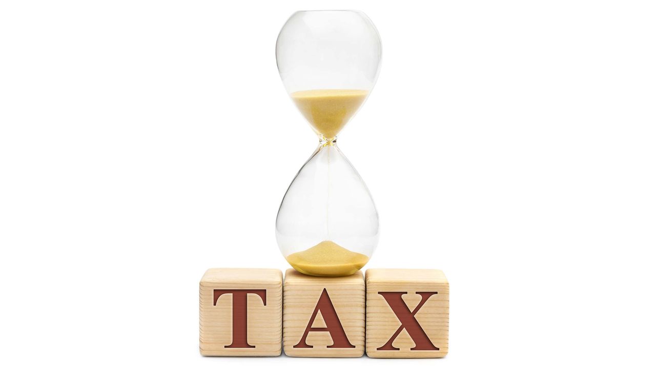 picture of an hour glass sitting on wood blocks with letters spelling &amp;quot;tax&amp;quot;