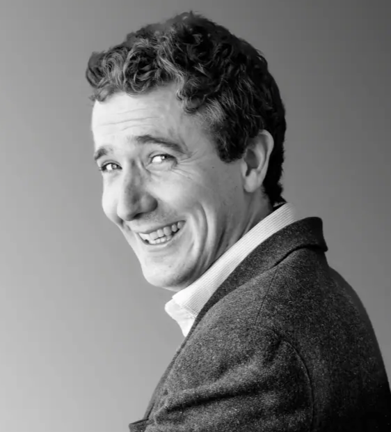 black and white headshot of man smiling to camera