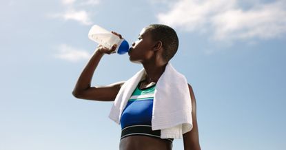 How much protein to build muscle: A woman drinking a protein shake