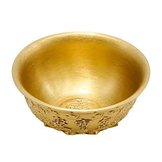 A round, shiny gold bowl with ornate embossing on the exterior