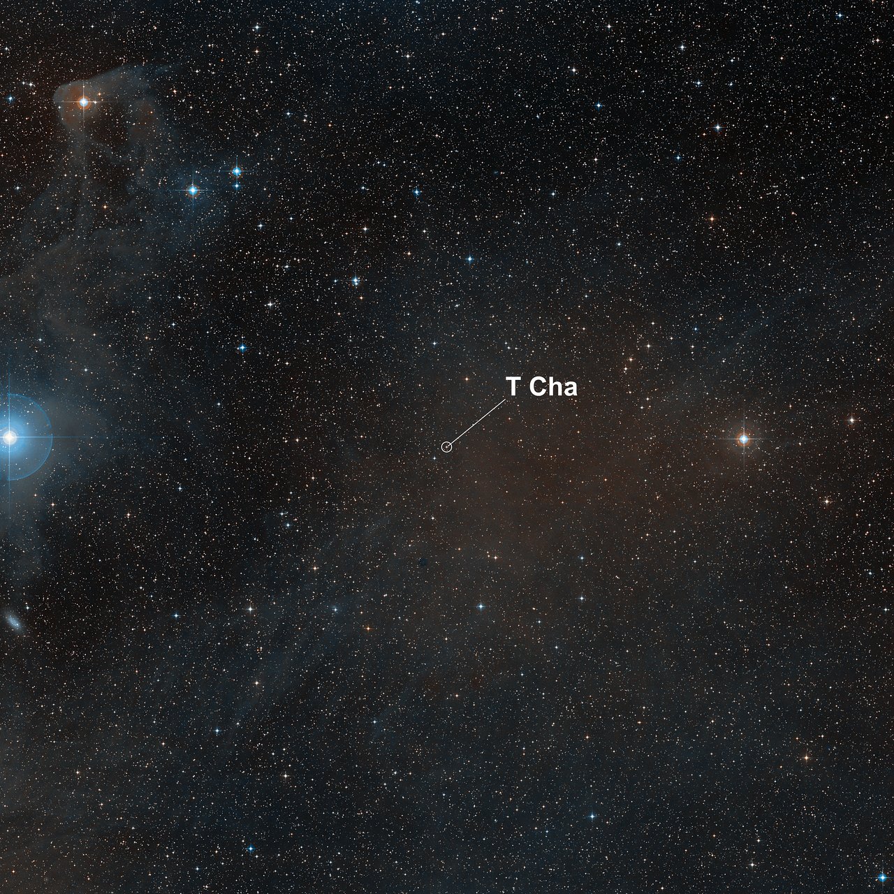 A view of a starry patch of sky with one area with an arrow indicating the location of T Cha.