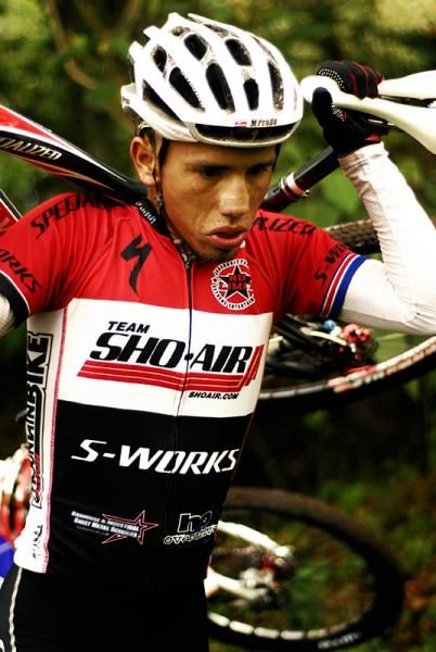 Costa Rican Manny Prado hikes with his bike.