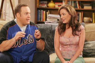 kevin james and leah remini sitting on a couch in the tv show king of queens