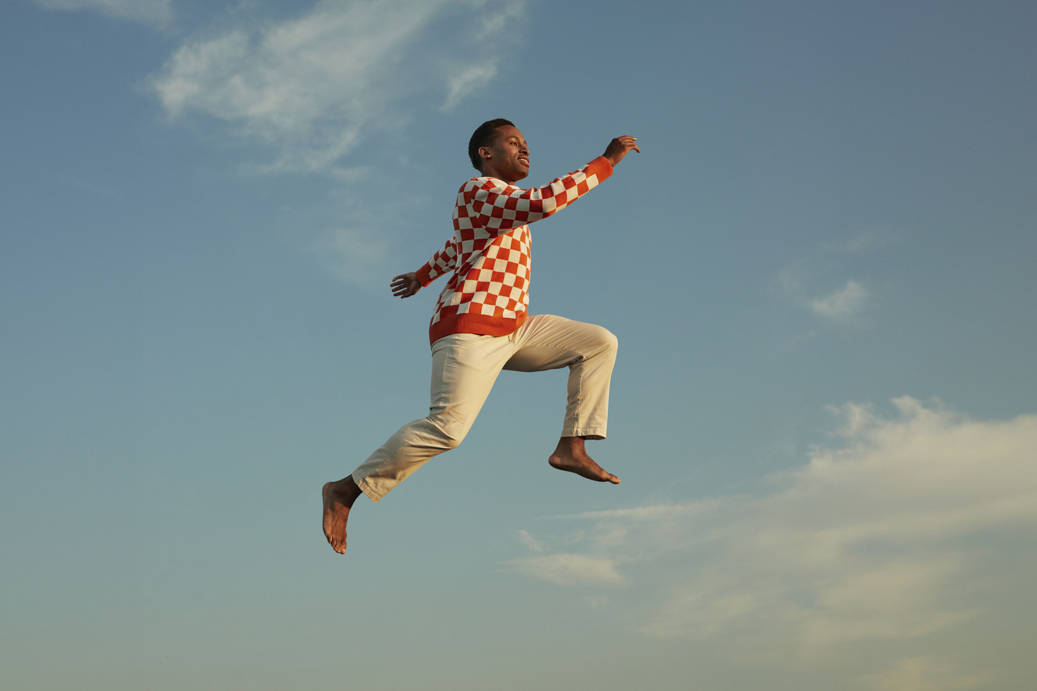 Man jumping in the sky with red jumper on