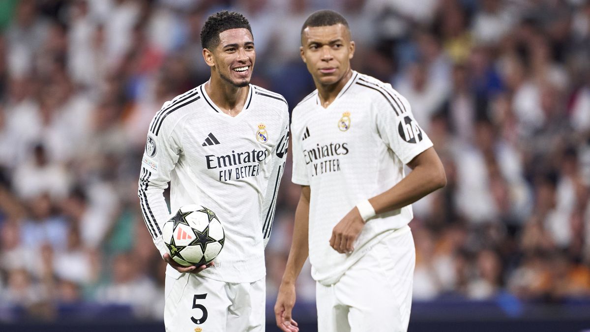 Jude Bellingham (L) and Kylian Mbappe discuss free kick duties during the Champions League, wearing the all white kit of Real Madrid.