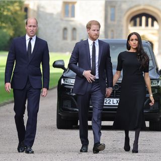 Prince WIlliam walking next to Prince Harry and Meghan Markle