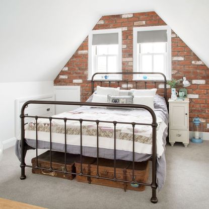 bedroom with sloping roof and white brickwall