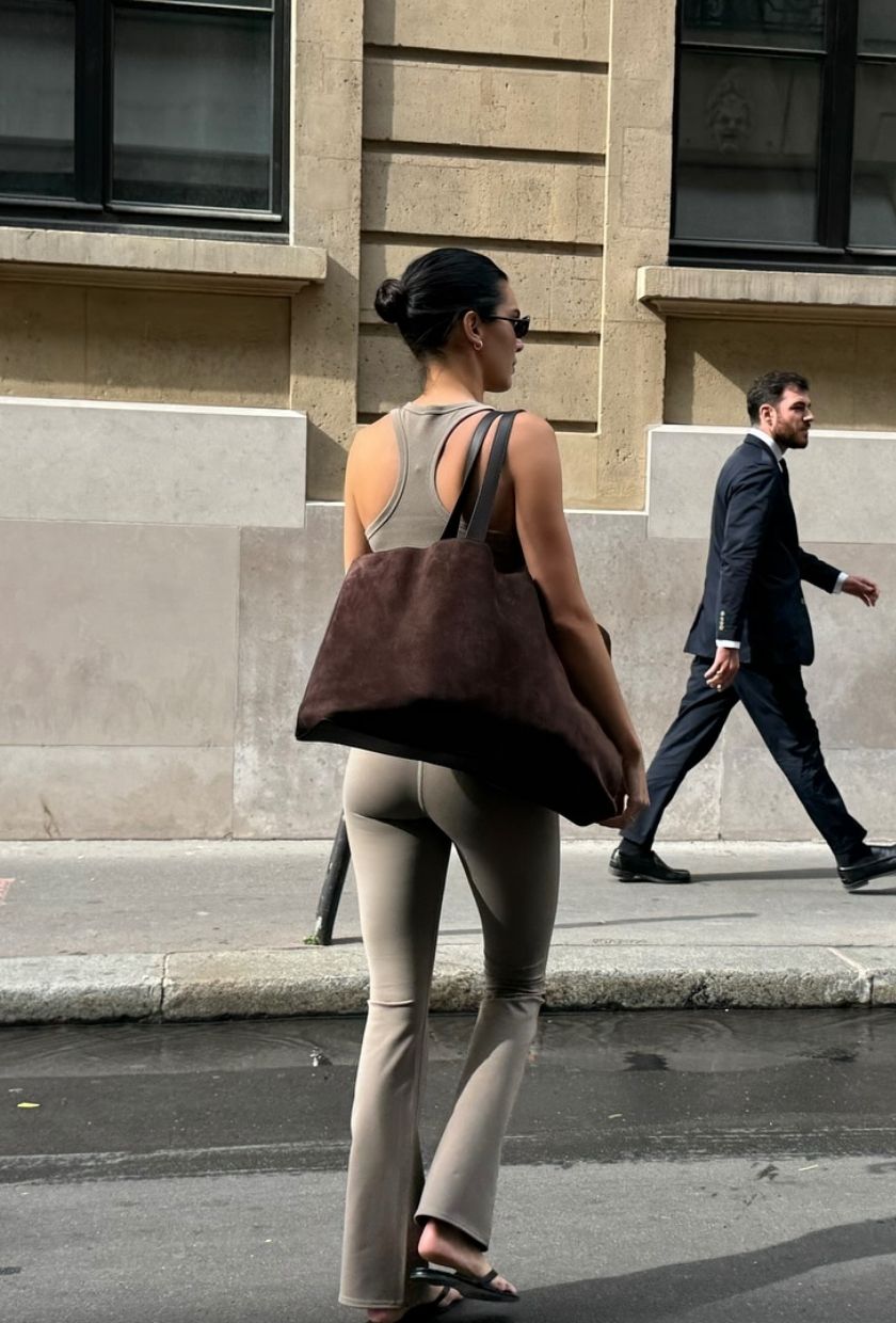 An image of @kendalljenner wearing bootcut leggings with flip-flops.