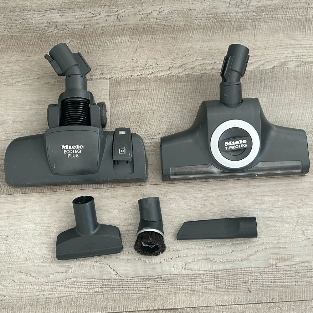 The five brush head attachments of the Miele Complete C3 Cat & Dog PowerLine laid out on Megan's floor