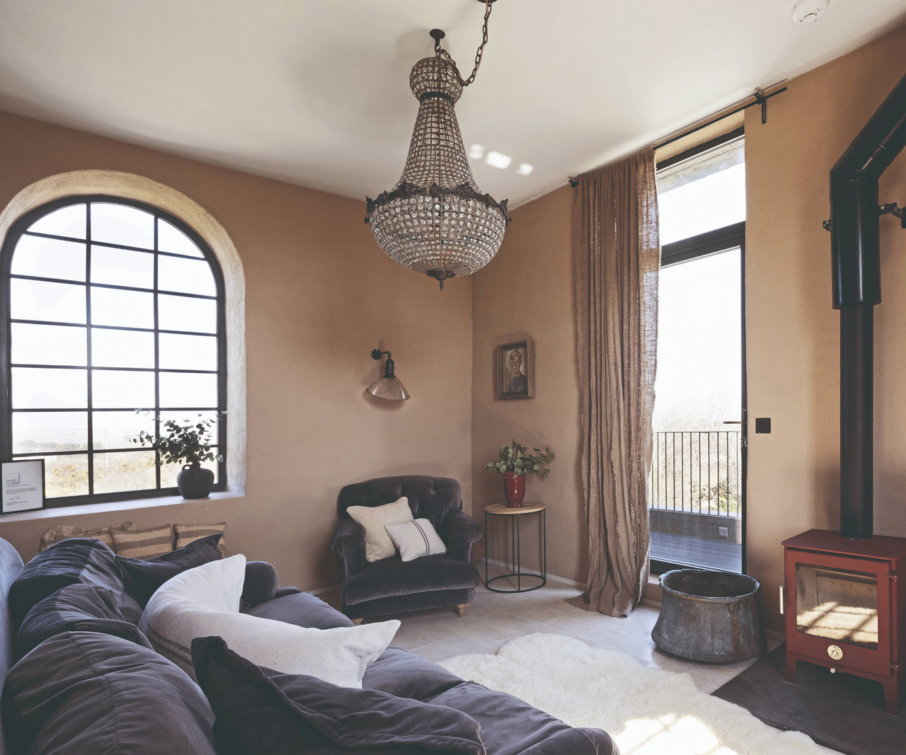 Living room with large arched window and log burner