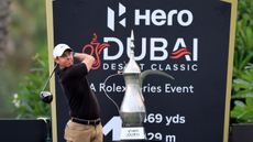 Rory McIlroy takes a shot with the trophy in view during the pro-am before the 2023 Dubai Desert Classic