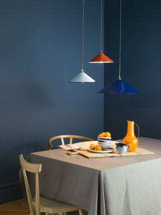Dark blue dining area with bright light fittings