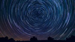 a long exposure photograph turns stars into circles of light in the night sky
