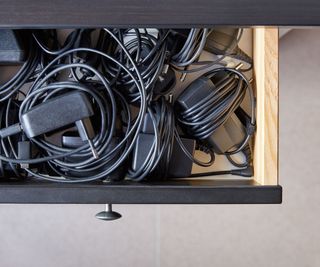 An open drawer full of organized cables