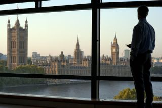 Businessman looking down at Houses of Parliament and River Thames
