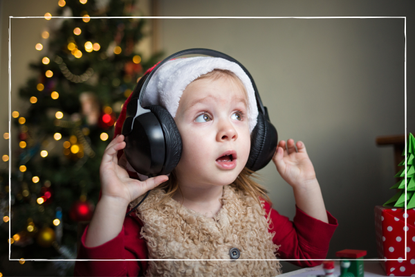 a close up of a child with headphones listenign to Christmas music for kids