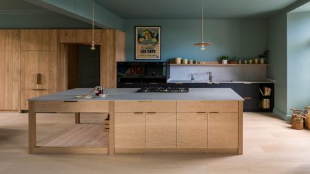 a classic timber kitchen with solid brass linear handles shown in a kitchen with green/blue painted walls and ceiling