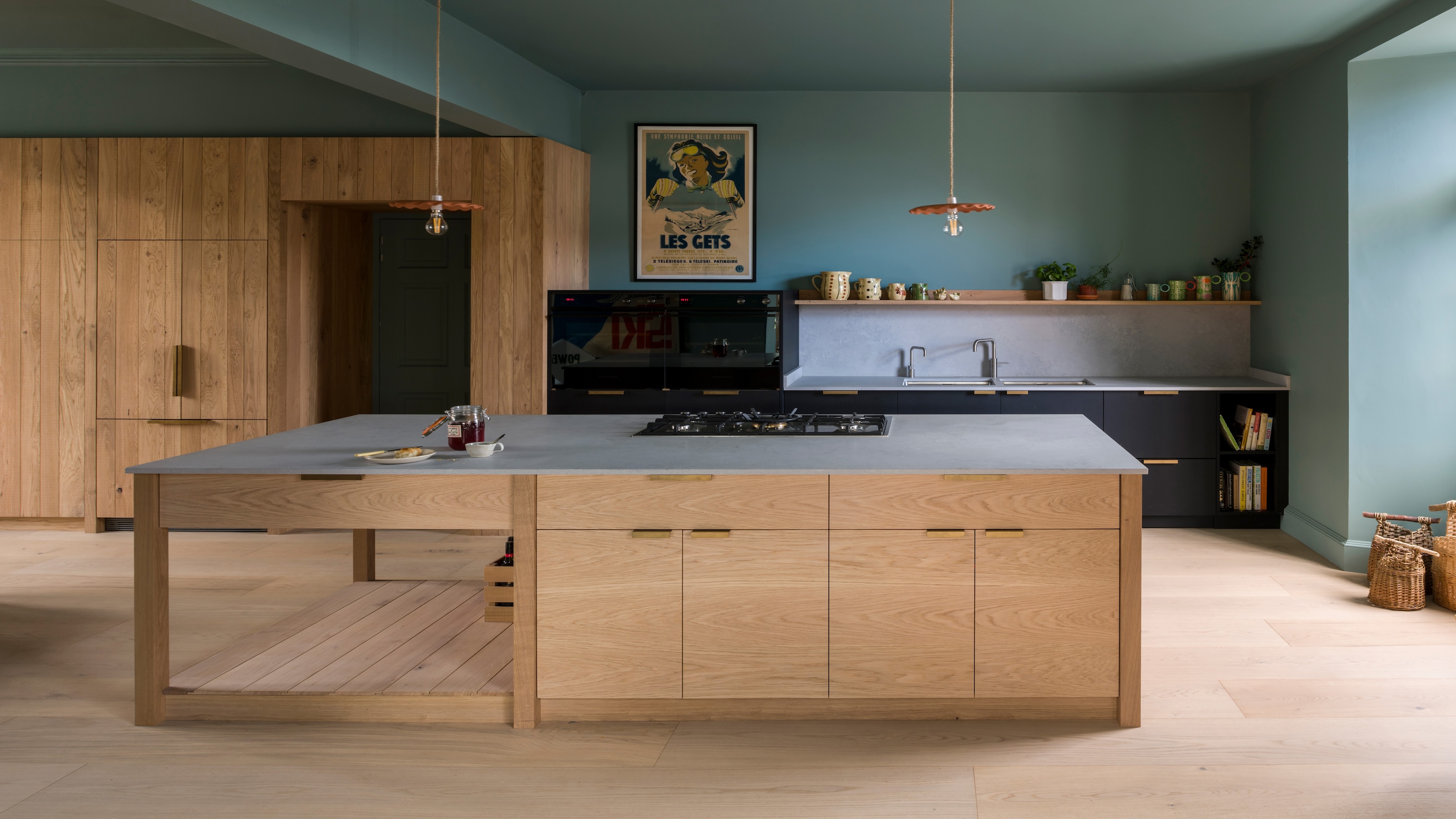 a classic timber kitchen with solid brass linear handles shown in a kitchen with green/blue painted walls and ceiling