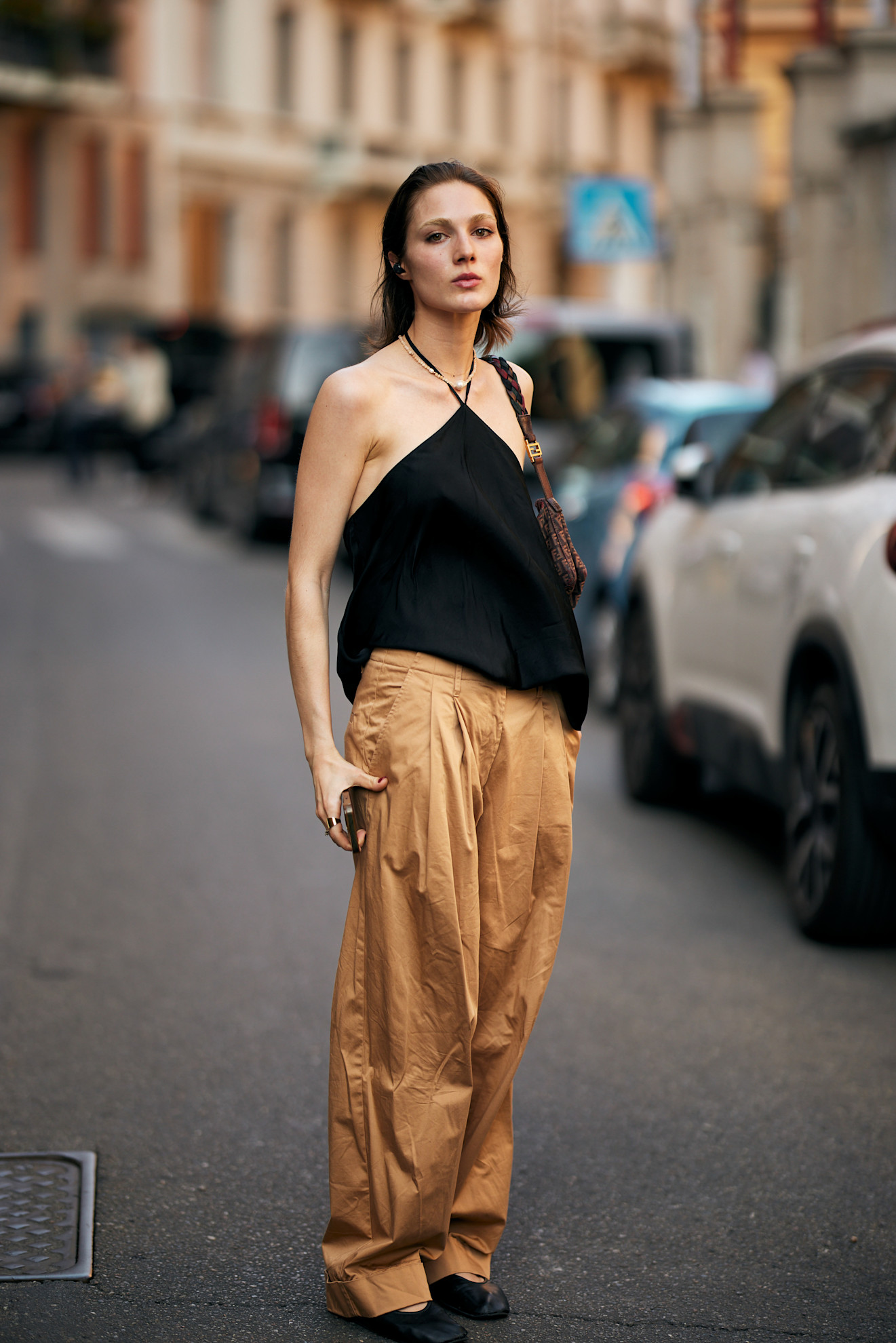 Milan Mens Fashion Week showgoer wears a halterneck top with trousers in Milan