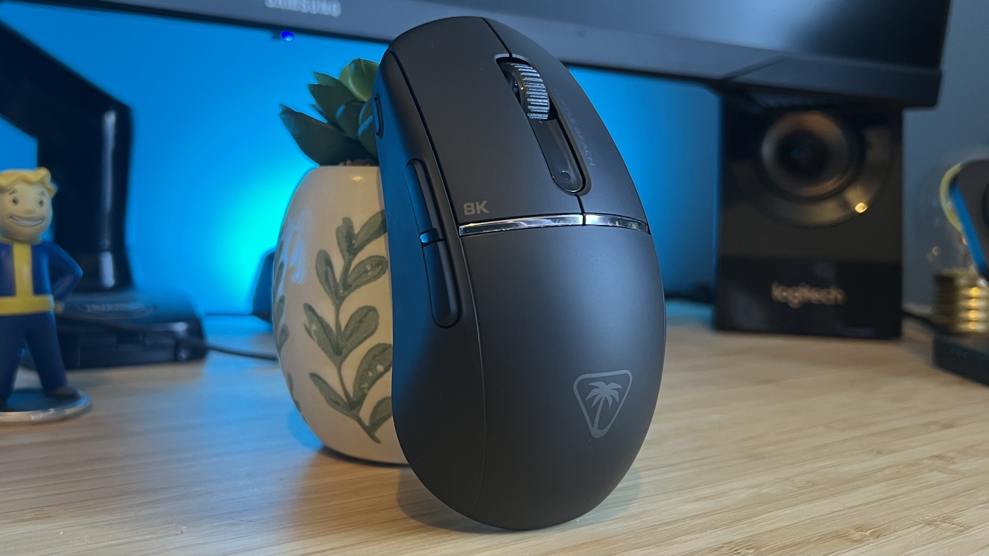 Turtle Beach Burst 2 Pro standing upright on a wooden desk with blue backlighting