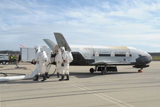 A recovery crew works on the X-37B space plane shortly after the spacecraft landed at Vandenberg Air Force Base in California on Oct. 17, 2014. The robotic X-37B spacecraft spent 674 days in orbit.