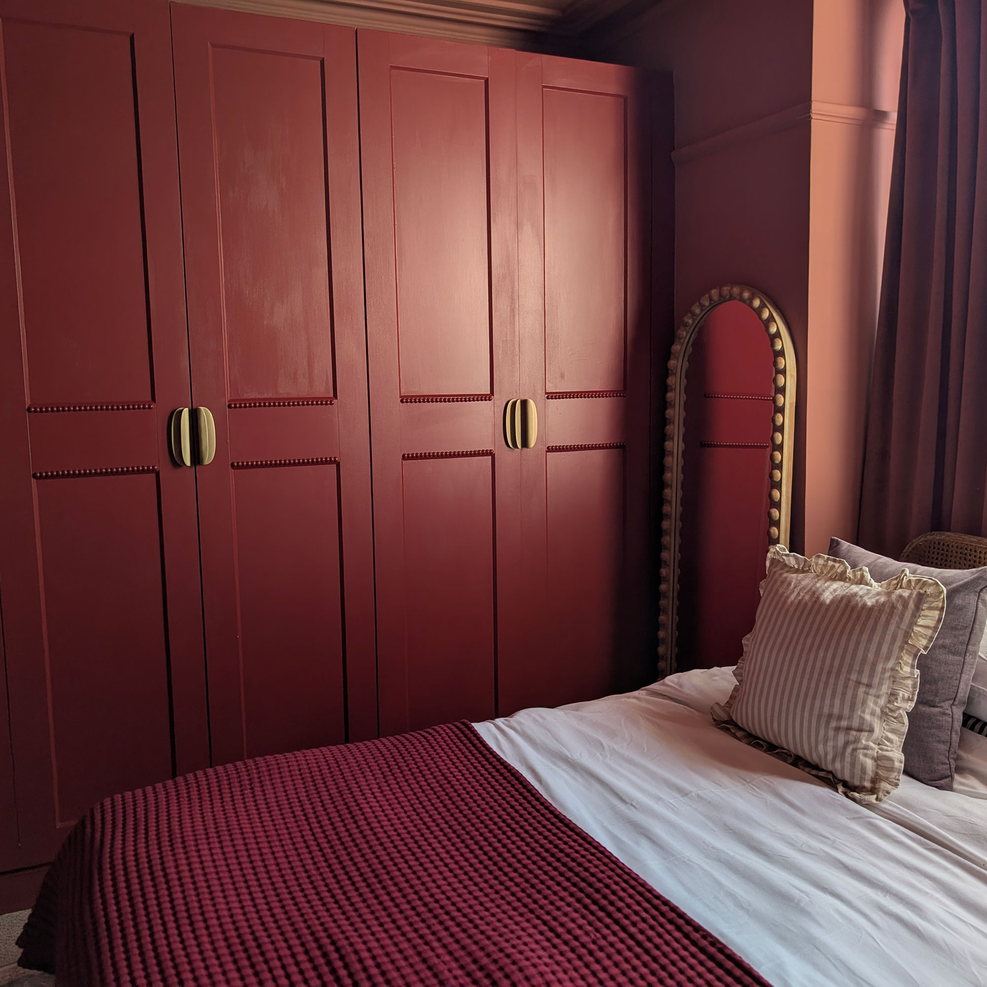 Red wardrobes with bobbin trim and gold hardware