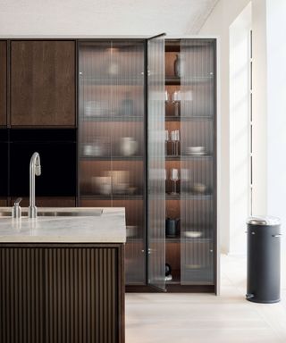 Large dark wooden larder with fluted glass panels