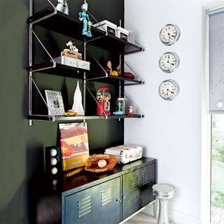 room with grey shelves on wall and wallclock