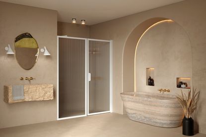 A shower room with beige walls, a free standing bath, and a shower with fluted panels