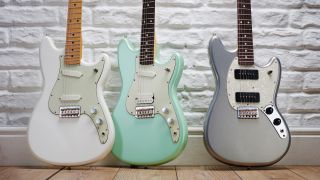 Three Fender Mustang guitars leaning against a wall