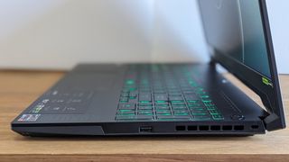 A black ASUS TUF Gaming A15 laptop on a wooden table