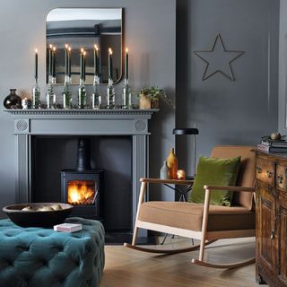 dark grey living room with rocking chair, sofa, fireplace and candlesticks on mantlepiece
