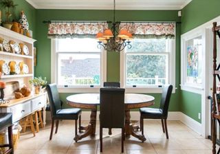 green wall dining area with table and chairs
