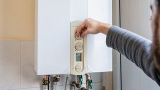 male adjusting dials on a boiler