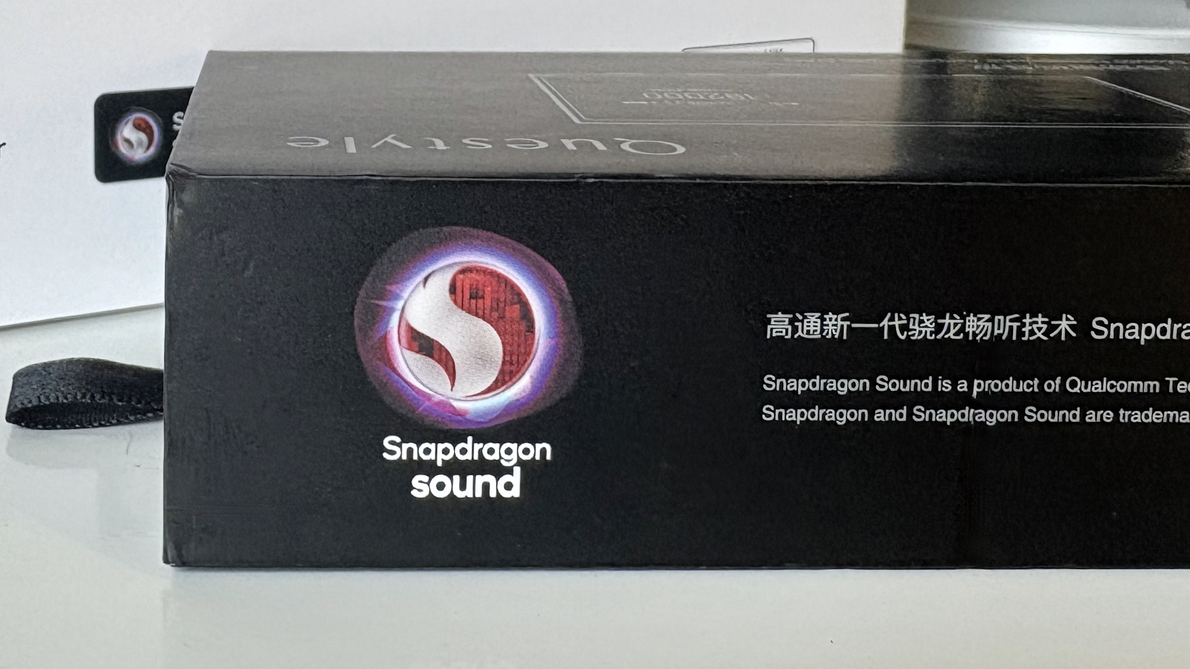 Qualcomm aptX branding, shown on portable hi-fi equipment packaging and a phone screen beside Bowers & Wilkins headphones