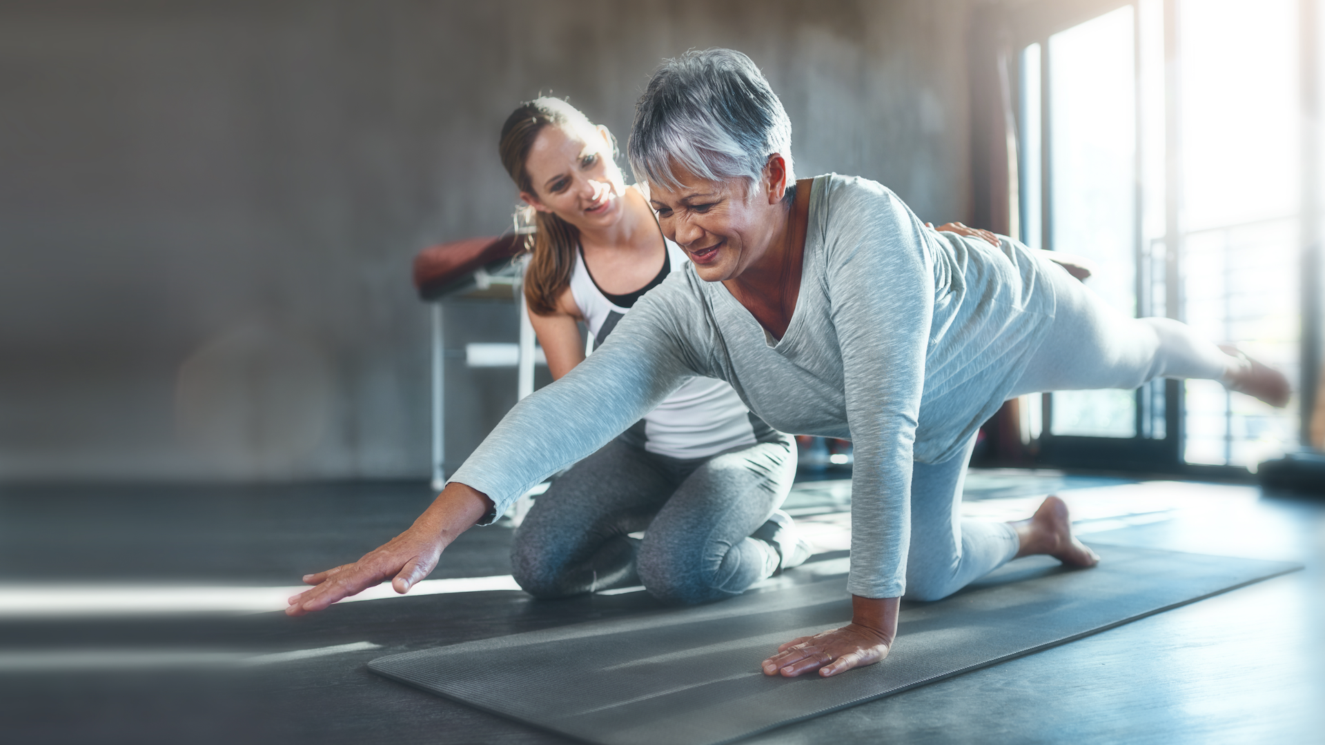 Woman doing mat Pilates being guided by an instructor
