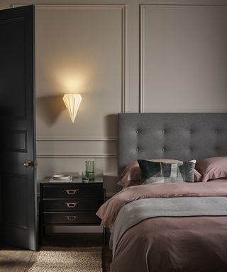 A bedroom wall lighting idea by Original BTC with pink duvet, grey headboard