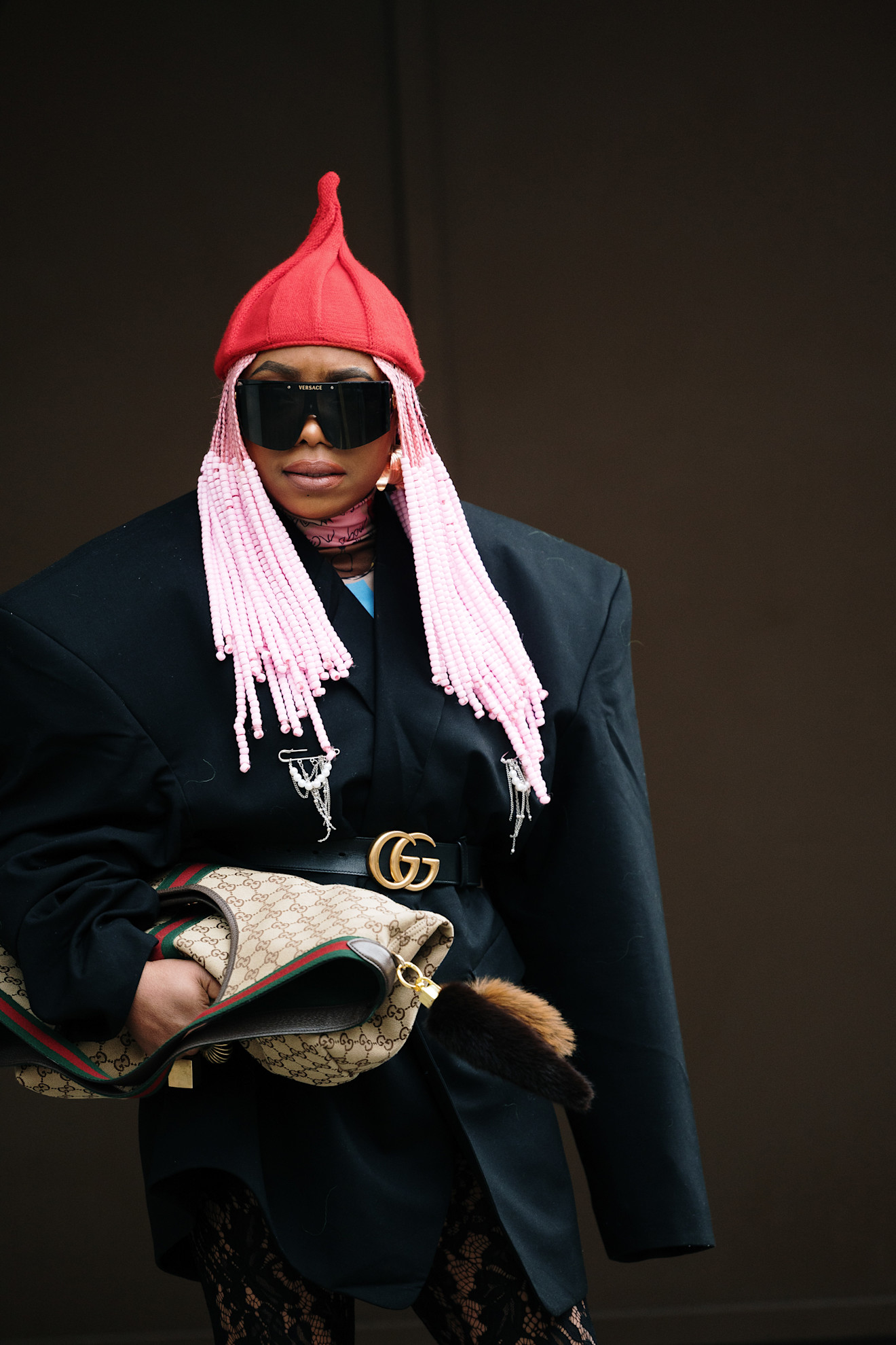 a woman with pink braids, red hat, and black jacket