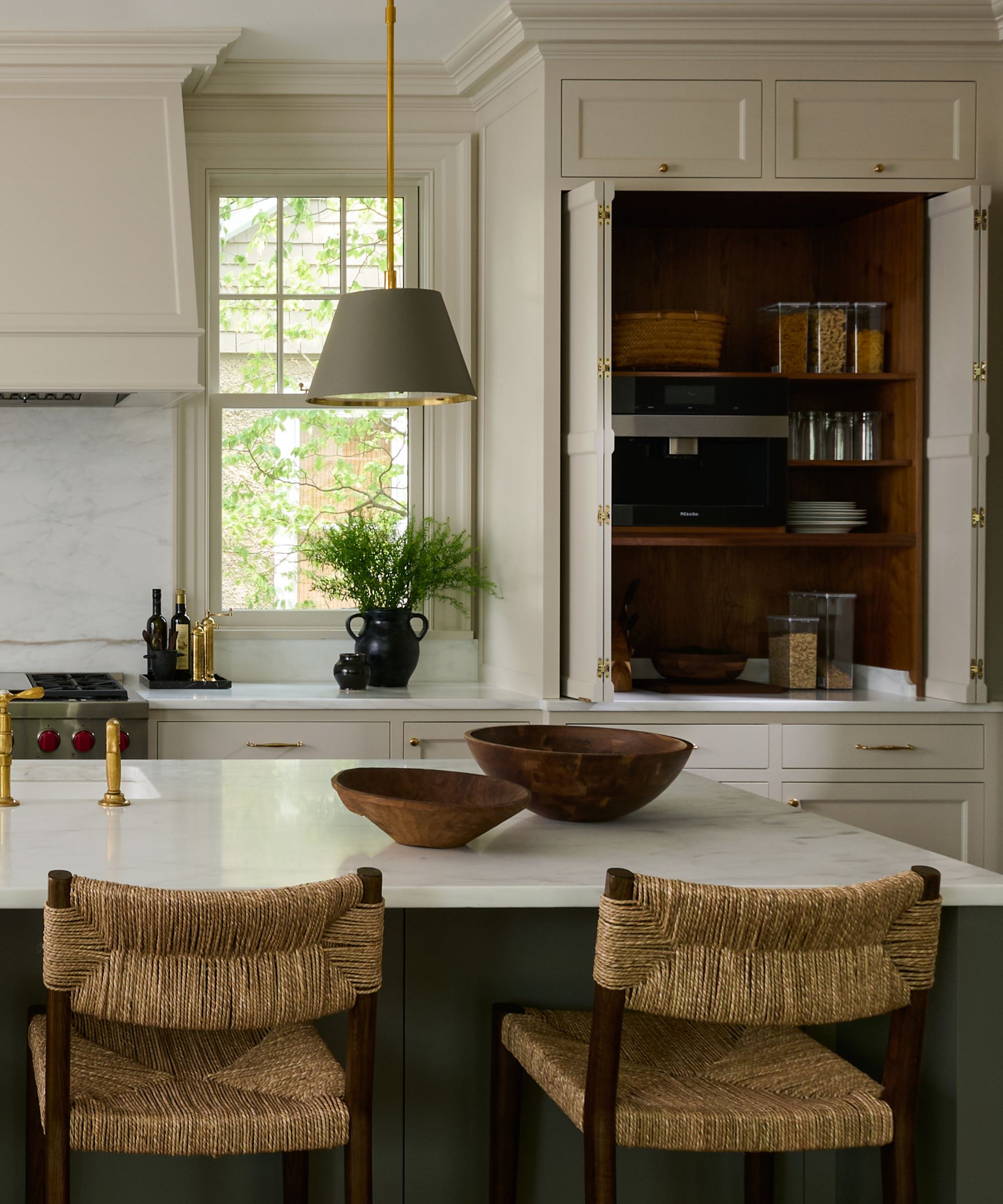 A warm white kitchen with a large cabinet that's been turned into a pantry