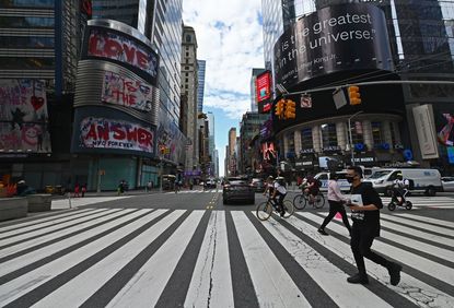 People cross the street near Time Square on September 28, 2020 in New York City. - Coronavirus infection rates have increased at "an alarming rate" in several New York neighbourhoods, particu