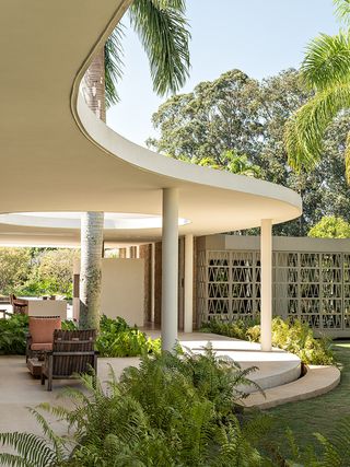 casa das palmeiras with its minimalist, low, white forms, curved openings and indoor/outdoor relationships in sao paulo's warm climate lifestyle