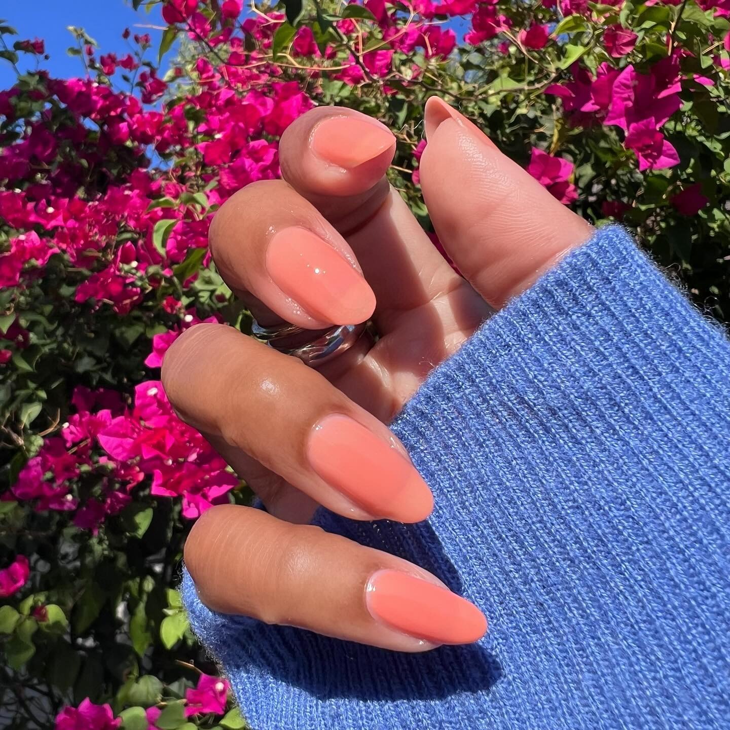 Person wearing peachy pink jelly nail polish.