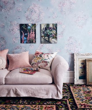 a pink and blue decoupage living room with a pink sofa, patterned carpet and artwork on the walls