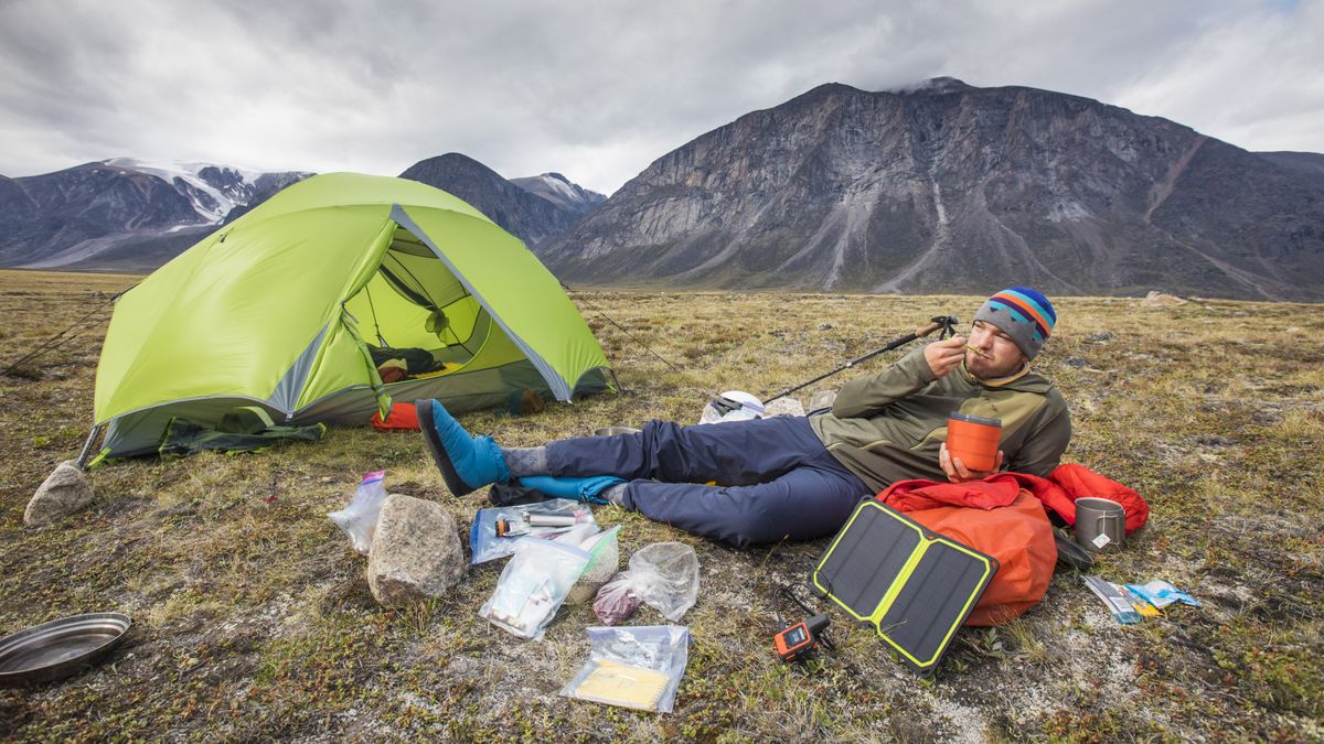 best solar charger: a camper powering up his tech with a solar charger